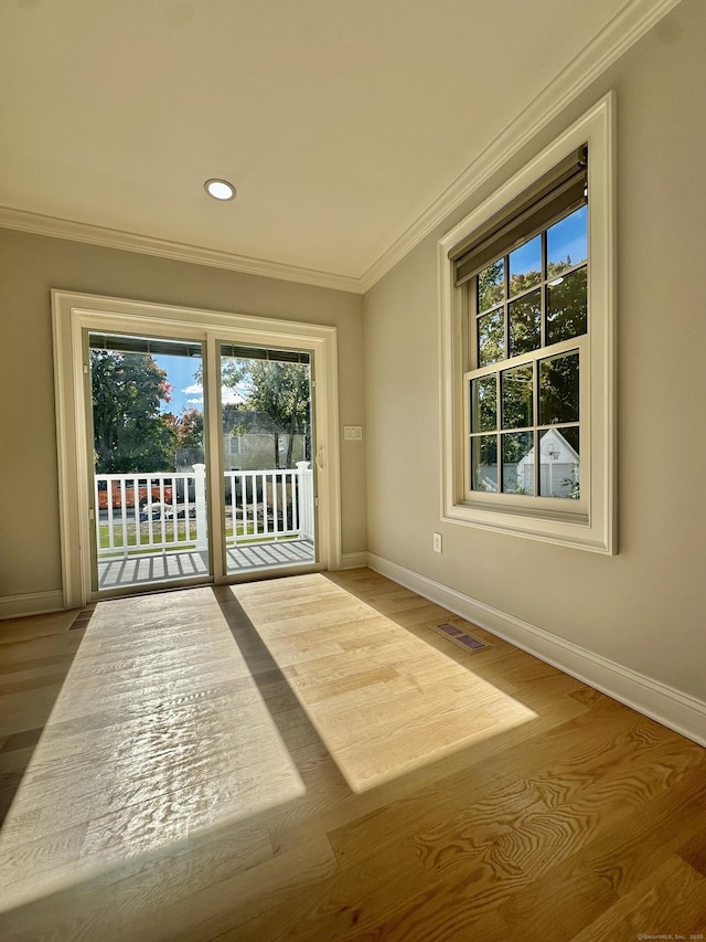 doorway featuring crown molding and light hardwood / wood-style flooring