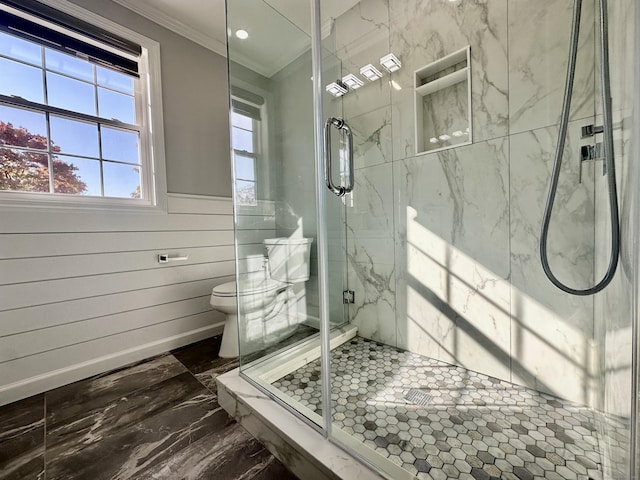 bathroom with toilet, crown molding, and an enclosed shower