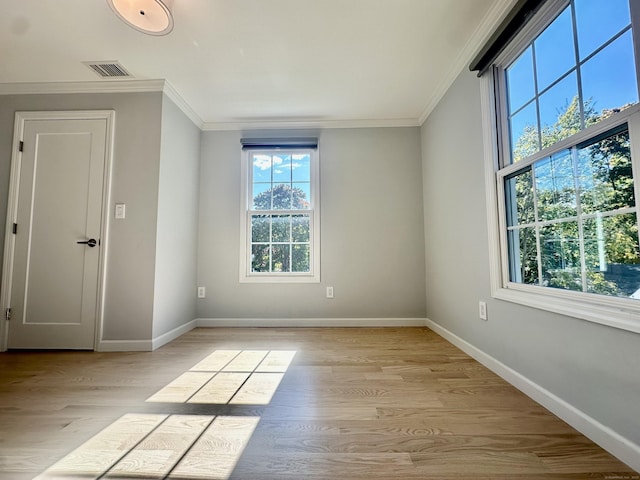 unfurnished room with light wood-type flooring and crown molding