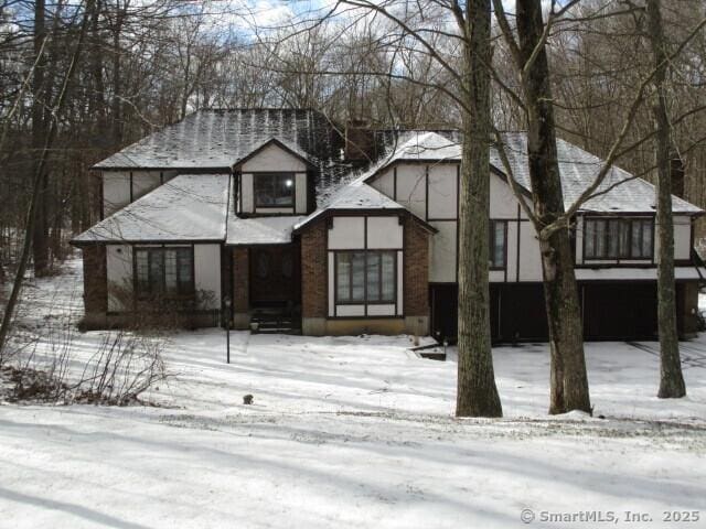 view of front of house with a garage and a shingled roof