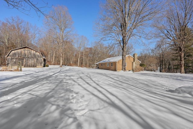 yard layered in snow with an outbuilding