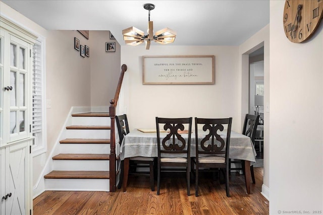 dining area with a wealth of natural light, a chandelier, and hardwood / wood-style flooring