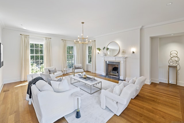 living room featuring light wood-type flooring, a notable chandelier, and ornamental molding