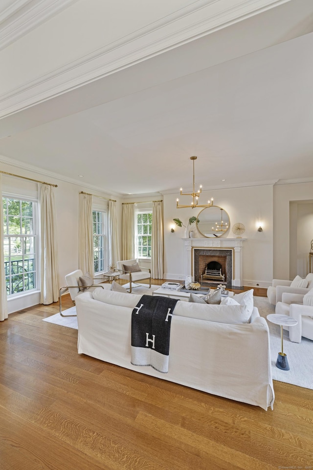 living room featuring a chandelier, ornamental molding, and light hardwood / wood-style flooring