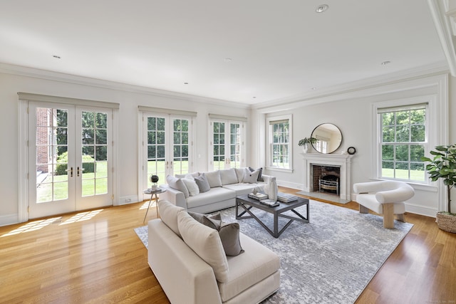 living room with light wood-type flooring, french doors, and ornamental molding