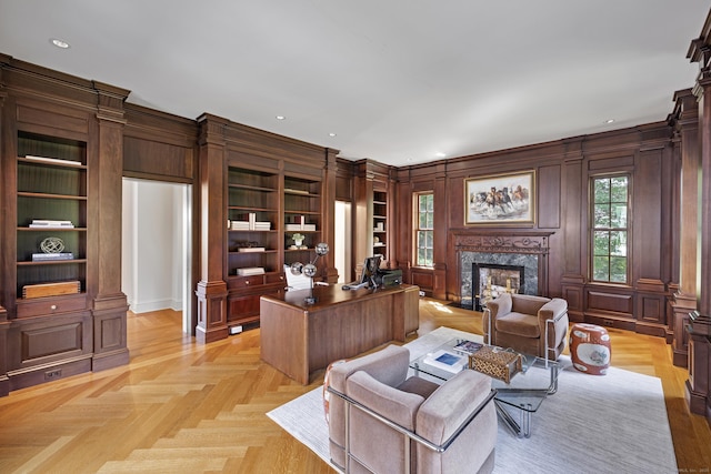 interior space featuring built in features, light parquet floors, a high end fireplace, and wooden walls