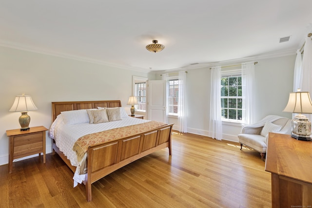 bedroom featuring ornamental molding and light hardwood / wood-style floors