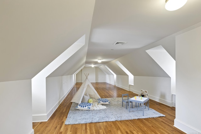 additional living space featuring wood-type flooring and vaulted ceiling