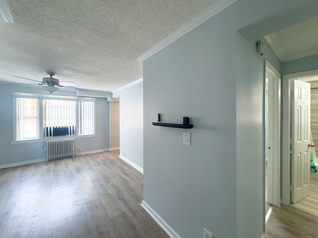 hallway with crown molding, radiator heating unit, light hardwood / wood-style flooring, and a textured ceiling