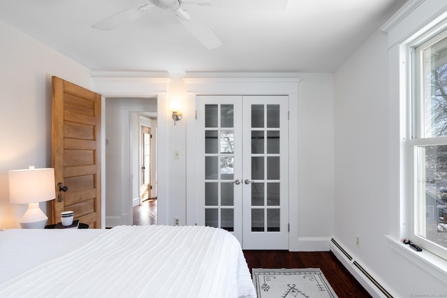 bedroom featuring a baseboard heating unit, dark wood-type flooring, ceiling fan, and french doors