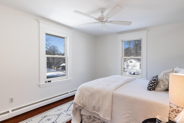 bedroom with a baseboard heating unit, hardwood / wood-style floors, and ceiling fan