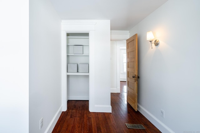 unfurnished bedroom with dark wood-type flooring, a closet, and a baseboard radiator