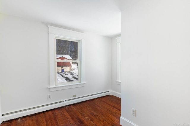 spare room featuring dark hardwood / wood-style floors and a baseboard heating unit