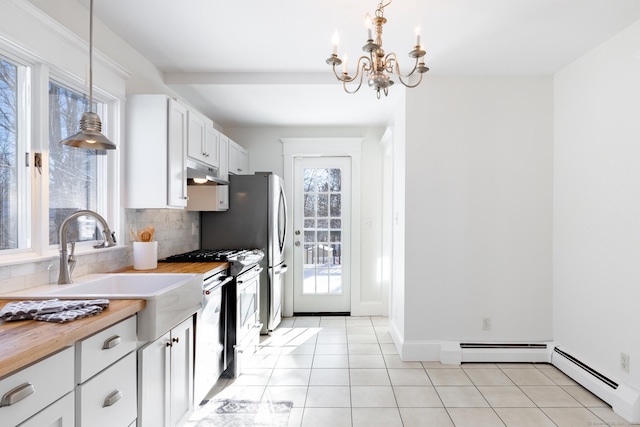 kitchen with a baseboard heating unit, decorative light fixtures, butcher block countertops, and white cabinets