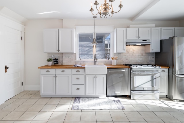 kitchen with sink, decorative light fixtures, wooden counters, and appliances with stainless steel finishes