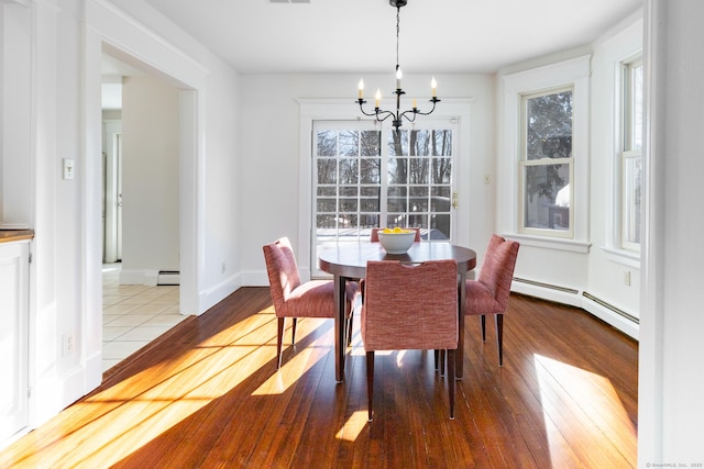 dining area featuring baseboard heating, a chandelier, light hardwood / wood-style flooring, and a wealth of natural light