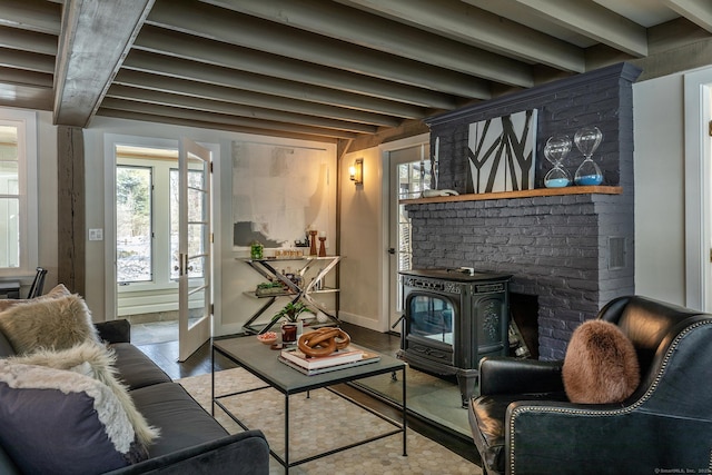 living room with beam ceiling, light hardwood / wood-style floors, french doors, and a wood stove