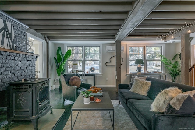 living room featuring plenty of natural light, rail lighting, a wall mounted AC, and a wood stove