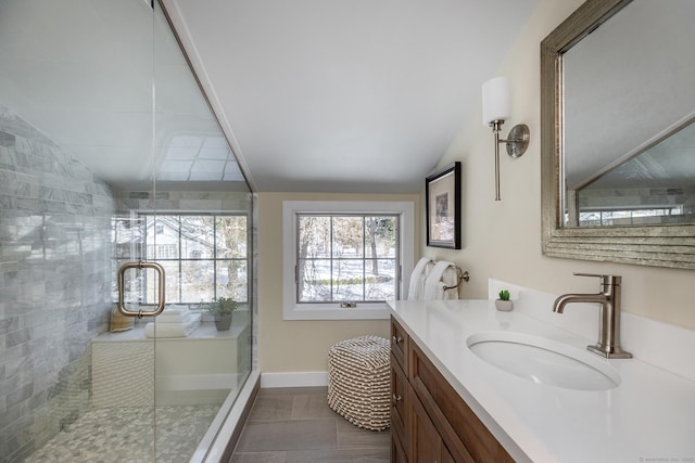 bathroom featuring tile patterned floors, vanity, a shower with shower door, and vaulted ceiling