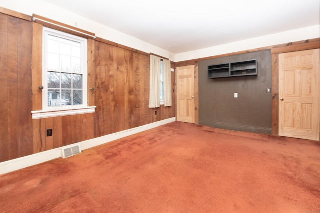 empty room with wood walls and carpet