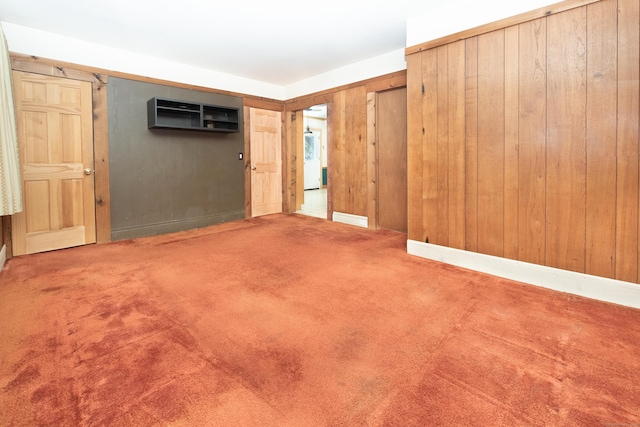 spare room featuring wooden walls, a wall unit AC, and carpet