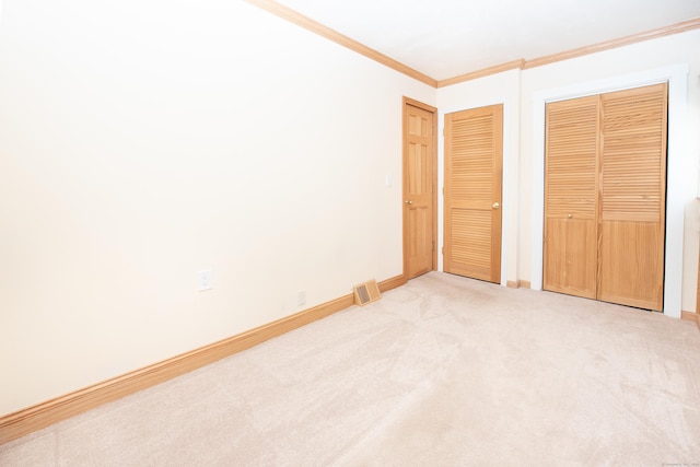 unfurnished bedroom with a closet, ornamental molding, and light carpet