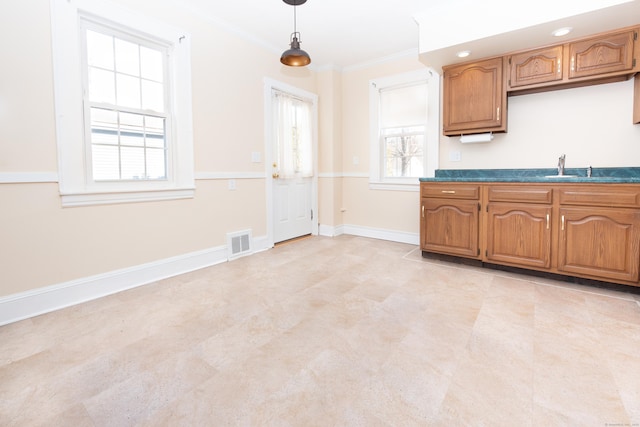 kitchen featuring crown molding, sink, and decorative light fixtures