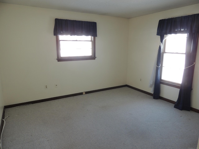 carpeted empty room with a healthy amount of sunlight