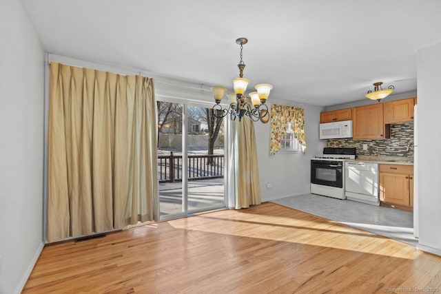 kitchen with white appliances, decorative light fixtures, decorative backsplash, light hardwood / wood-style floors, and a chandelier