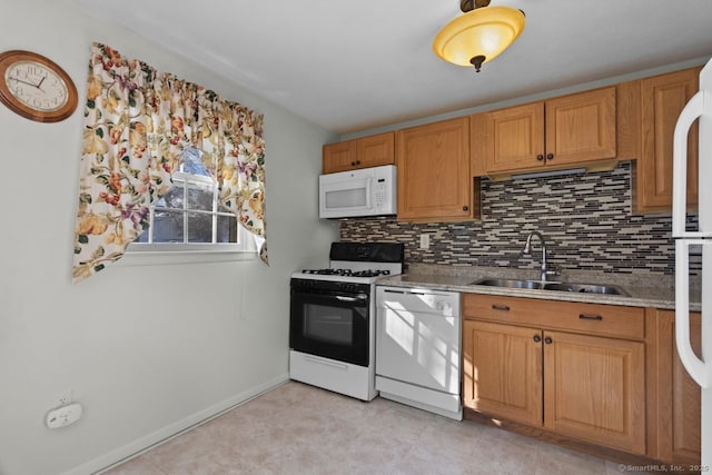 kitchen with light stone countertops, sink, white appliances, and backsplash