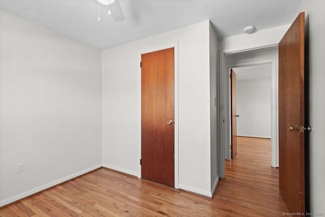 unfurnished bedroom with ceiling fan, a closet, and light hardwood / wood-style floors