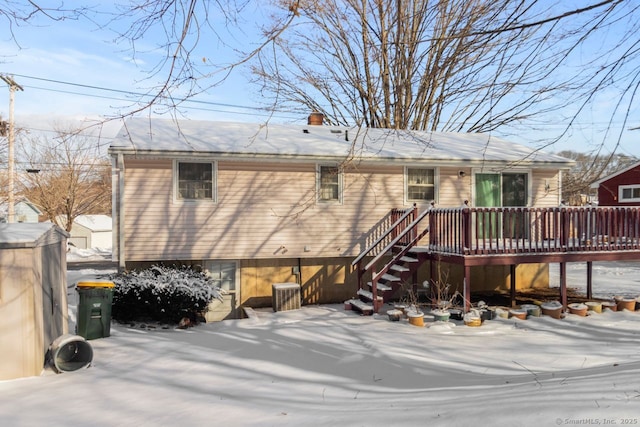 snow covered house featuring a wooden deck