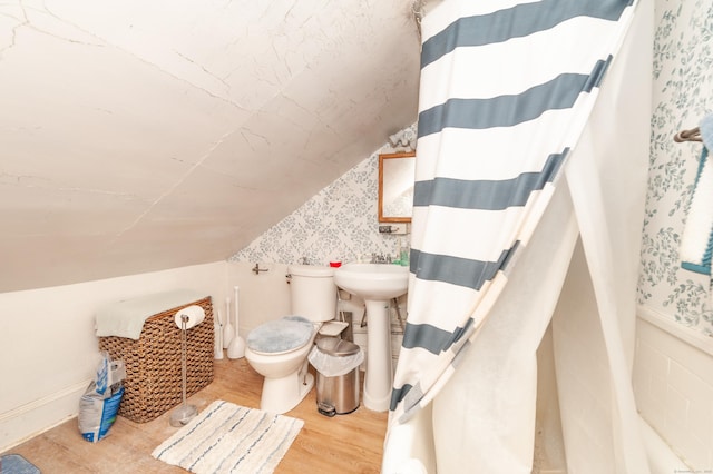 bathroom with a shower with shower curtain, lofted ceiling, toilet, and hardwood / wood-style floors