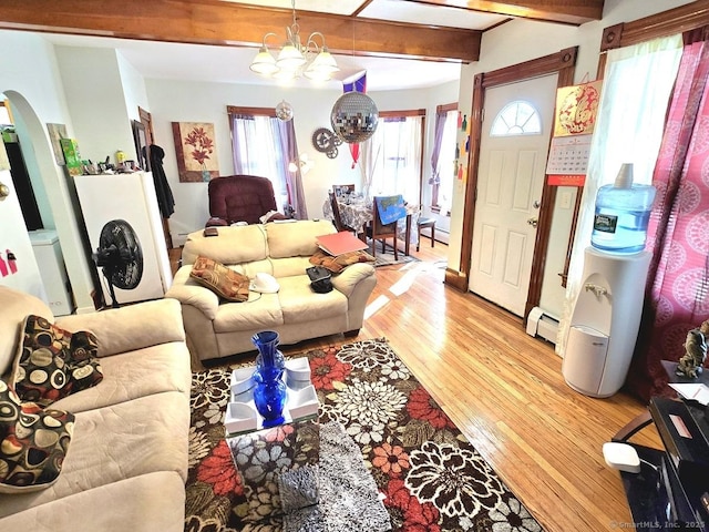 living room featuring a baseboard radiator, an inviting chandelier, beam ceiling, and light wood-type flooring