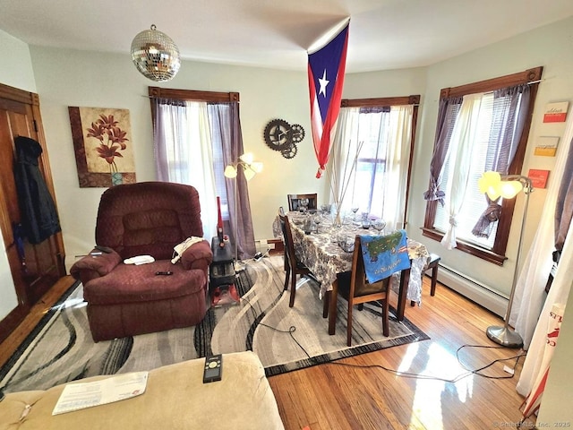 dining area featuring baseboard heating and hardwood / wood-style floors