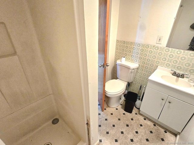 bathroom featuring toilet, vanity, and walk in shower