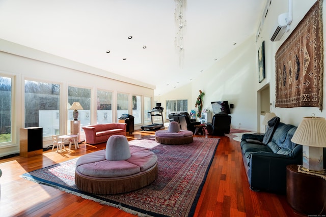 living room with hardwood / wood-style flooring, a towering ceiling, and a wall mounted AC