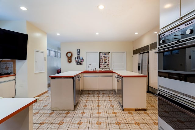 kitchen featuring a kitchen island, dishwasher, white cabinetry, and sink