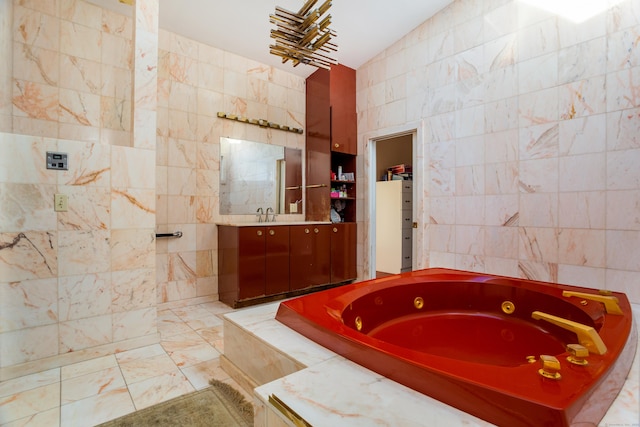 bathroom featuring tile walls, tiled tub, and vanity