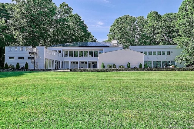 rear view of property featuring a lawn