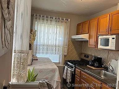 kitchen featuring decorative backsplash, stainless steel gas stove, and sink