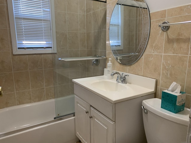 full bathroom featuring tile walls, toilet, vanity, and combined bath / shower with glass door