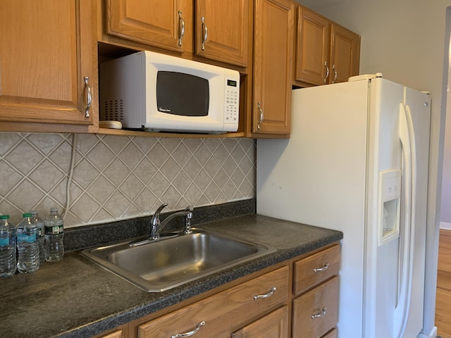 kitchen with sink, backsplash, and white appliances