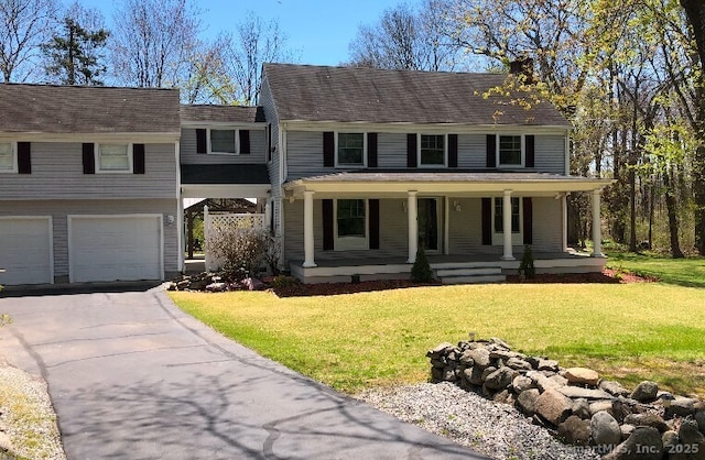 view of front facade with a garage, a front yard, and a porch