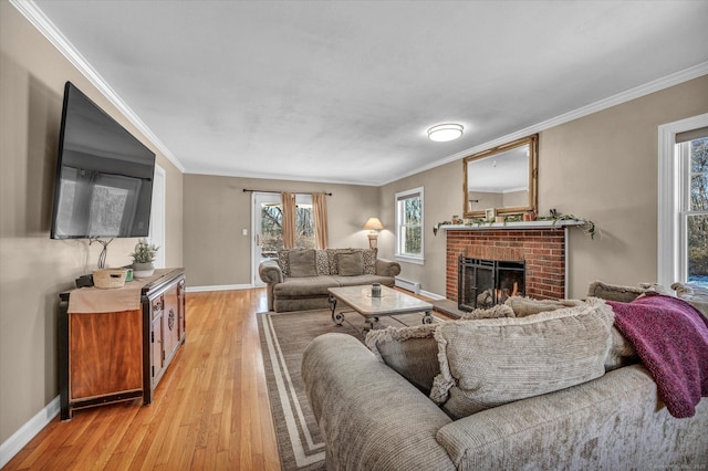 living room featuring ornamental molding, a fireplace, and light hardwood / wood-style flooring