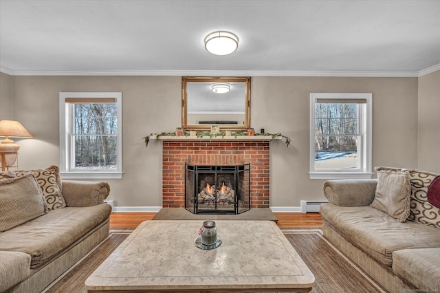 living room featuring hardwood / wood-style flooring, a fireplace, crown molding, and a baseboard heating unit