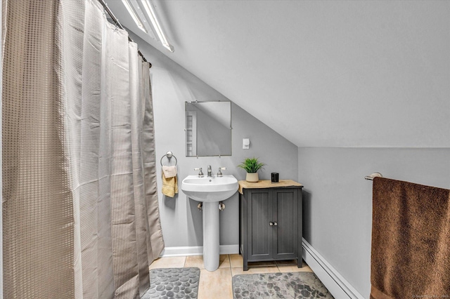 bathroom with tile patterned flooring, lofted ceiling, sink, and baseboard heating