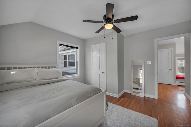 bedroom featuring hardwood / wood-style floors, vaulted ceiling, and ceiling fan