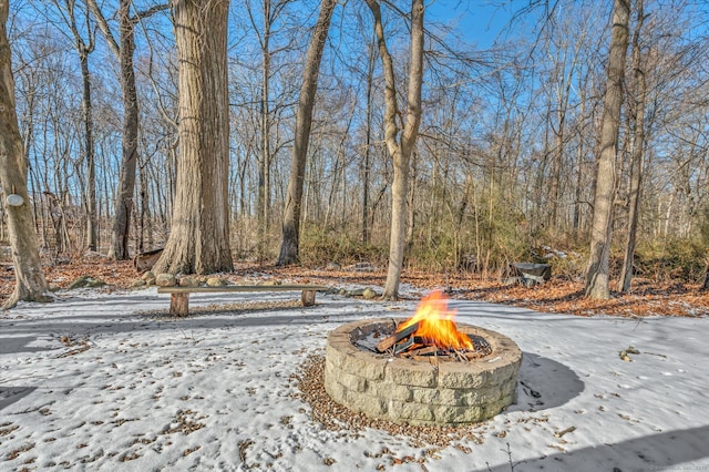 yard layered in snow with an outdoor fire pit