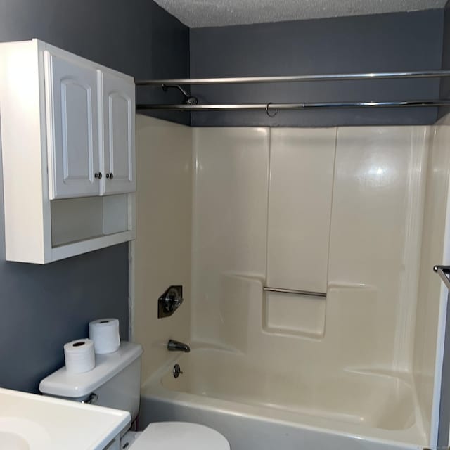 full bathroom with toilet, vanity, tub / shower combination, and a textured ceiling